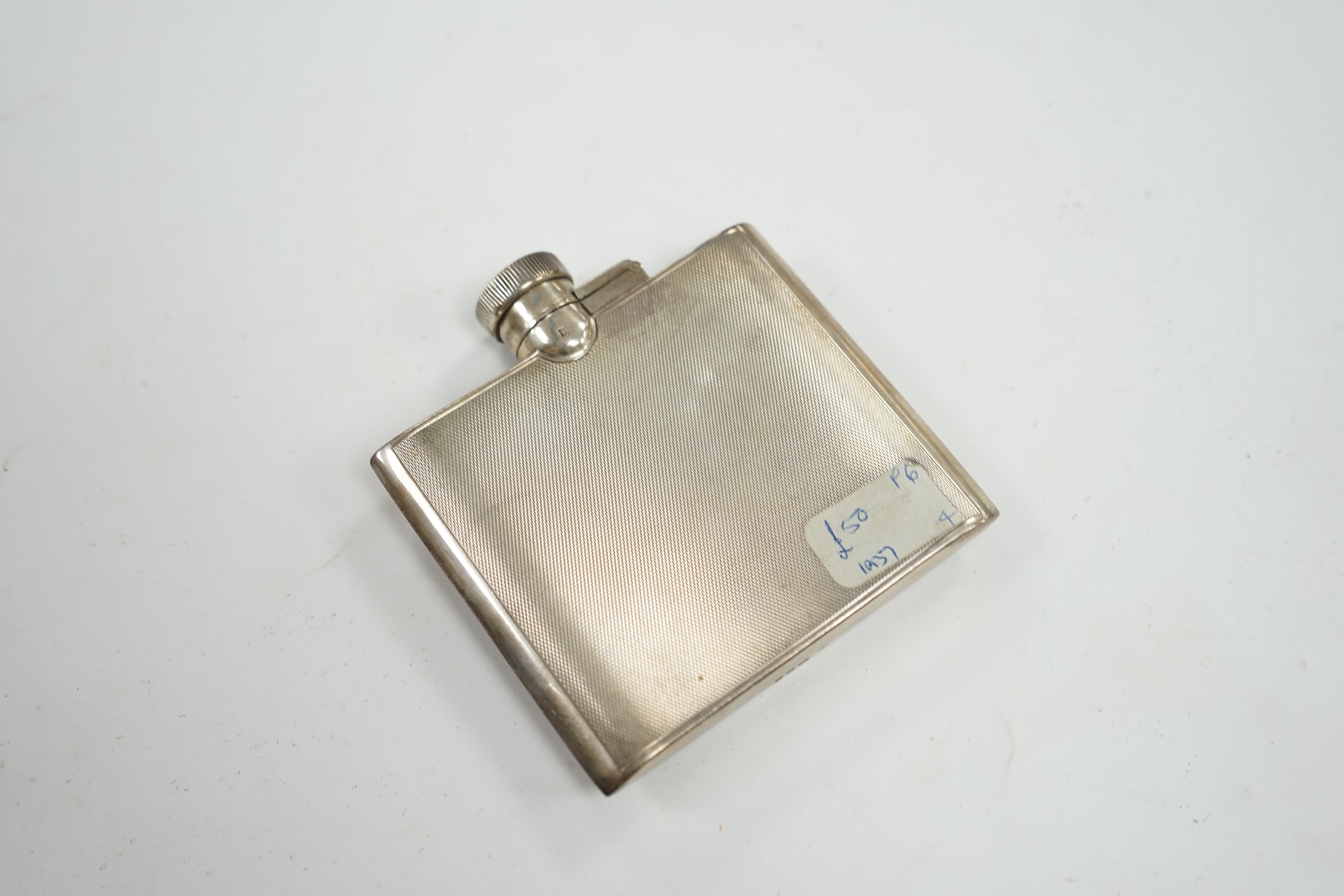 A George VI engine turned silver hip flask, Goldsmiths & Silversmiths Co Ltd, London, 1937, 95mm. Condition - fair